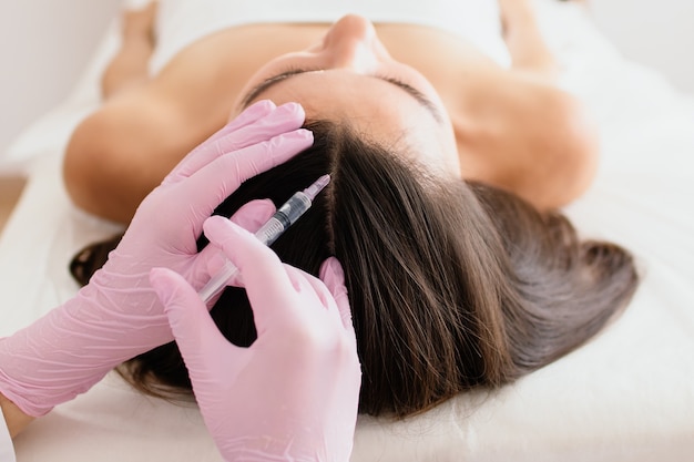 Haarbehandeling in de cosmetologie met mesotherapie-injectie in het hoofd