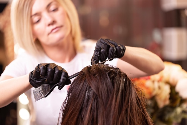 Haarkleuring in de salon haarstyling Professionele tovenaar schildert het haar in de salon Schoonheidsconcept haarverzorging