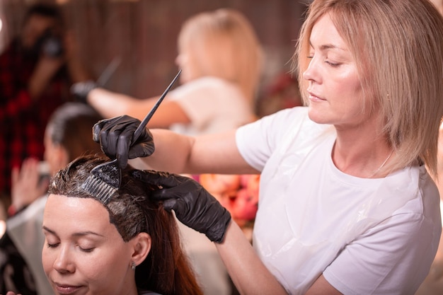 Haarkleuring in de salon haarstyling Professionele tovenaar schildert het haar in de salon Schoonheidsconcept haarverzorging