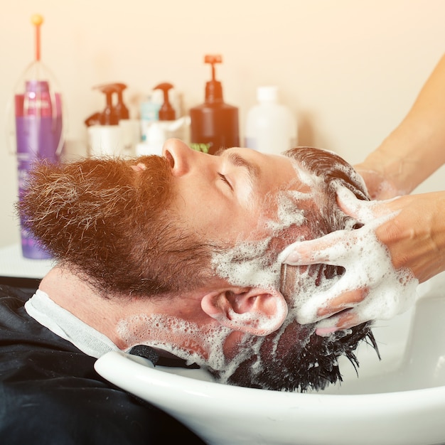 Haarstylist Kapper wassen klant haar brutale man ontspannen in kappers schoonheidssalon
