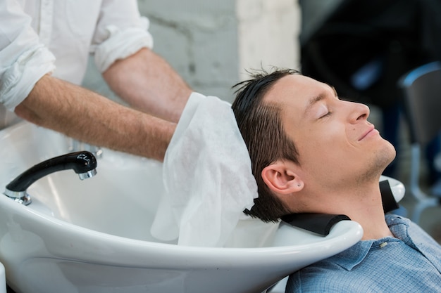 Haarstylist wassen van klant haar in de kapper