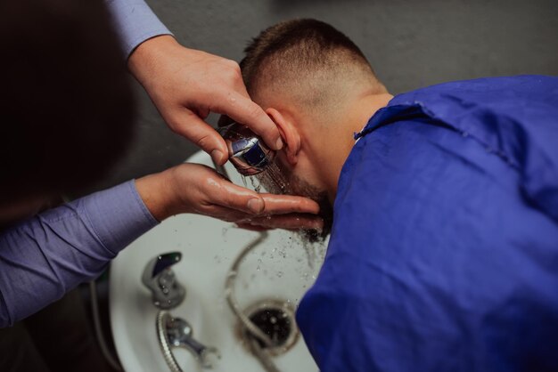 Haarstylist wast beren van klant 39s in een kapperszaak Selectieve focus Foto van hoge kwaliteit