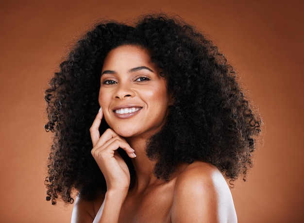 Haarverzorging schoonheid en portret van zwarte vrouw met afro op bruine achtergrond in studio voor wellness Schoonheidscosmetica en gelukkig vrouwelijk model met gloeiende huid gezond en natuurlijk krullend kapsel