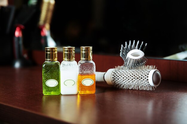 Haarverzorgingsbalsems in fles en haarborstel.