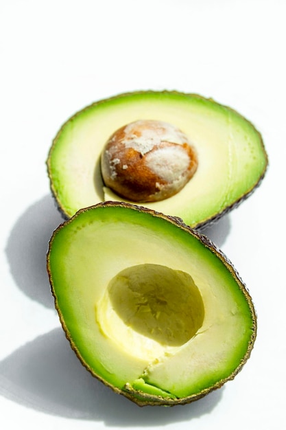 Haas verse avocadohelften met pit Rijp nuttig biologisch fruit Close-up Bovenaanzicht Geïsoleerd op witte achtergrond Verticaal