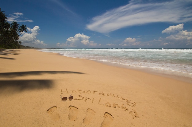 Spiaggia di habaraduwa, a sud dello sri lanka. oceano ondulato e cielo nuvoloso