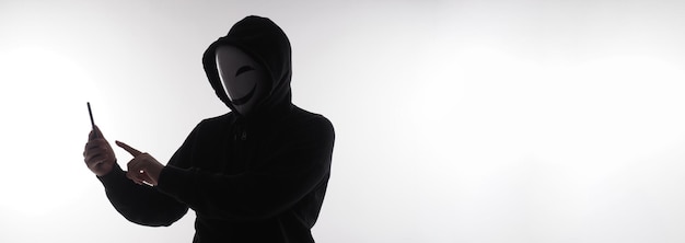 Hacker Anoniem en gezichtsmasker met smartphone in de hand