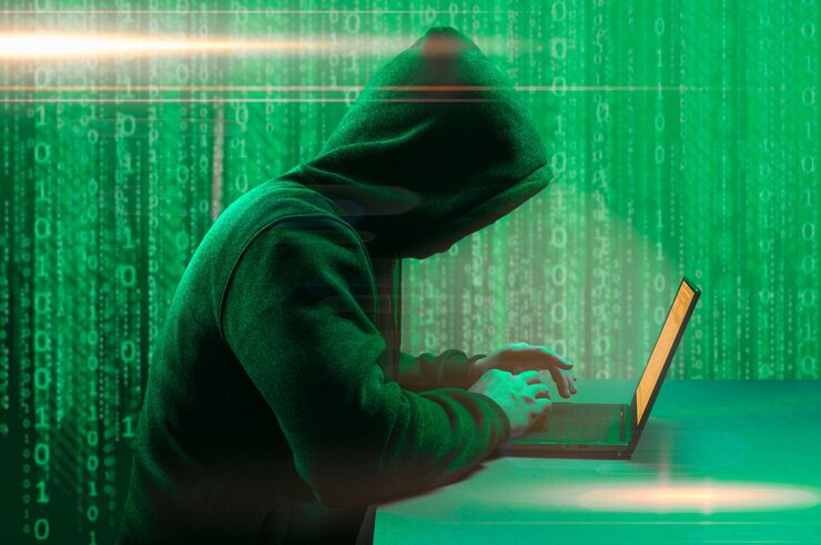 Photo hacker attack faceless hooded anonymous computer hacker hacker man with laptop attack to server network system online in data internet security hacking concept dark green background