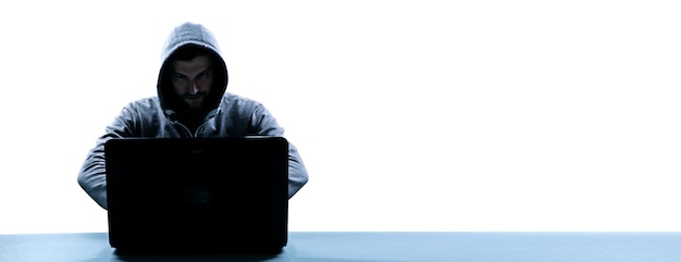 Hacker drukt een code af op een laptoptoetsenbord om in te breken in een cyberspace