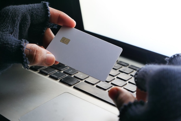 Mano di hacker che ruba dati dalla carta di credito