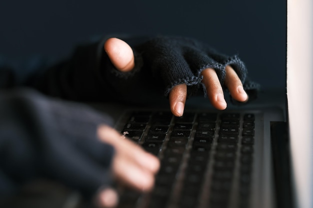 Photo hacker hand stealing data from laptop top down