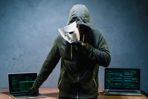 Hacker holding mask