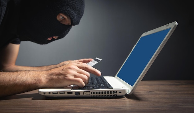 Hacker met creditcard en laptop computer Cybercriminaliteit