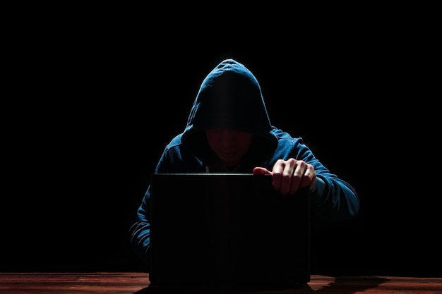 Hacker met laptop op zwarte achtergrond