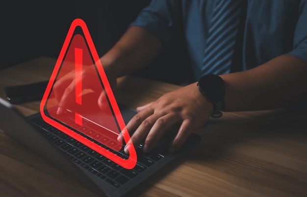 Hacker of programmeur die een laptop gebruikt met een driehoekige waarschuwingscode
