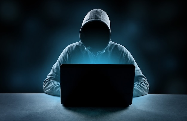 hacker prints a code on a laptop keyboard to break into a cyberspace