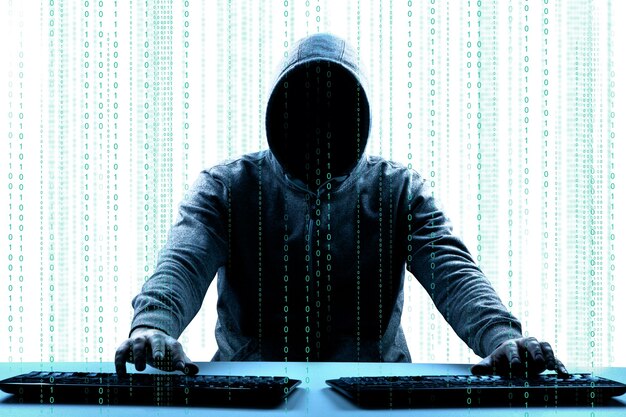 Hacker stampa un codice sulla tastiera di un laptop per entrare in un cyberspazio