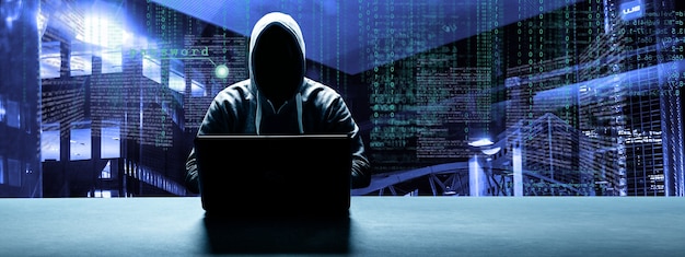 Хакер печатает код на клавиатуре ноутбука, чтобы проникнуть в киберпространство