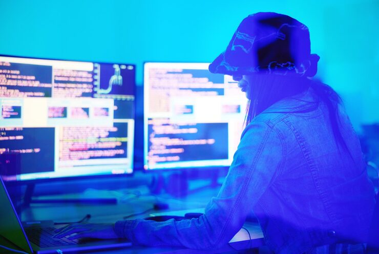 Photo hacker programmer and woman typing on laptop in home at night in neon light to hack software cybersecurity ransomware phishing and female coder coding on computer for hacking database with malware