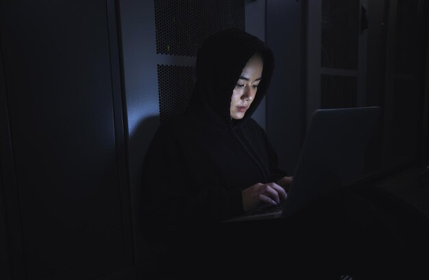 Hacker serverruimte en persoon op laptop voor het coderen van software datacentercriminaliteit en cyberpunk in het donker Netwerk hackende vrouw of gebruiker in cybersecurity informatietechnologie of programmeur ransomware