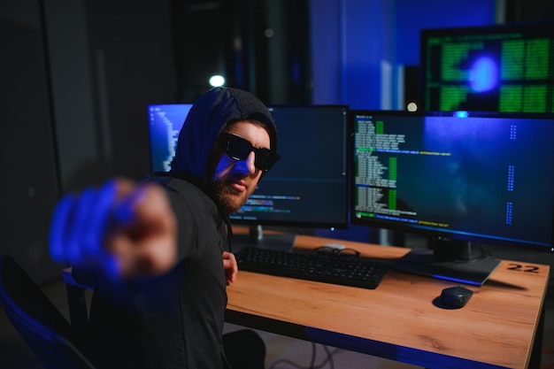 hacker sitting at desk in dark atmosphere a computer programmer or hacker anonymous computer hacker