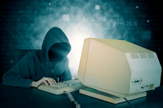 Хакер печатает на клавиатуре с фоном двоичного кода