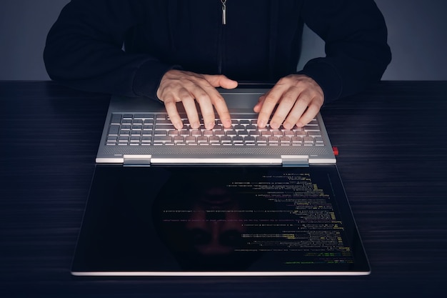 hacker using laptop. lots of digits on the computer screen. modern slim ultrabook transformer on the table. program code amer, software code, programme code.