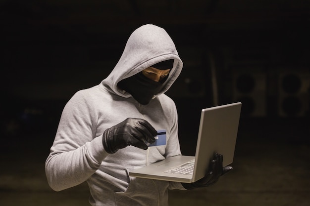 Hacker using laptop to steal identity