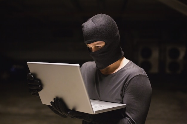 Hacker using laptop to steal identity