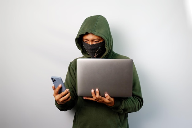 Photo hacker using laptop to steal personal data from people and calling someone to request a ransom
