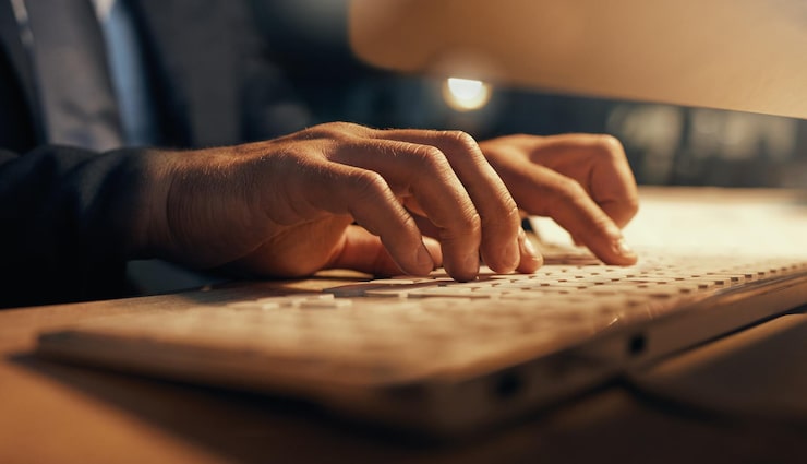 Photo hacker web developer or software designer typing on computer keyboard for research coding or programming closeup hands of a man internet browsing while working late night on cyber security code
