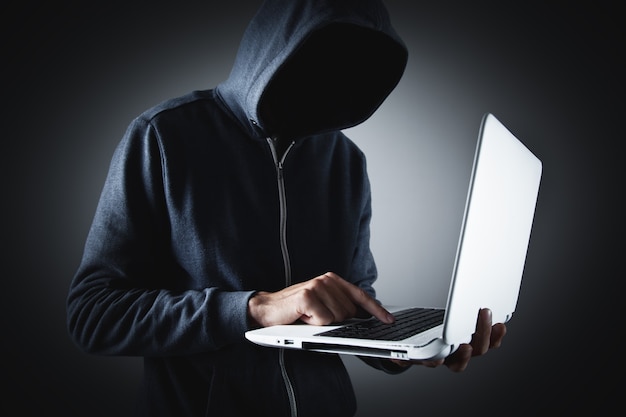 Hacker with laptop. Computer crime.