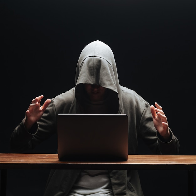 노트북을 가진 해커가 범죄를 계획했습니다.