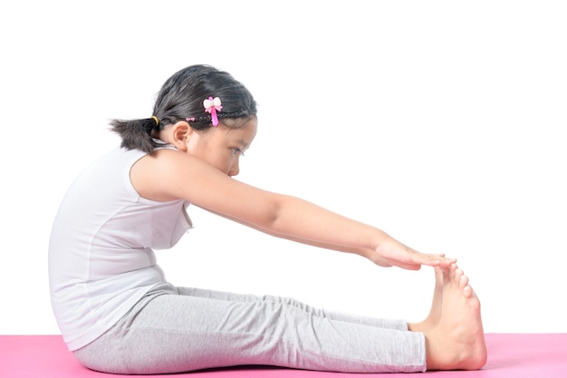 Haealthy asian kid exercise on yoga mat isolated 