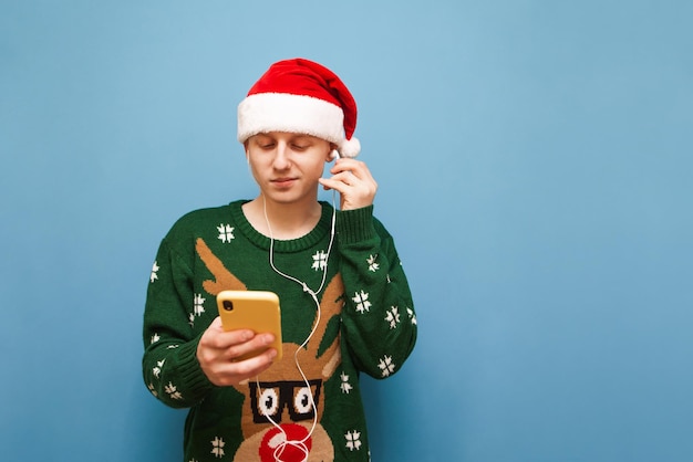 HaGuy in a sweater and a santa hat listens to Christmas music