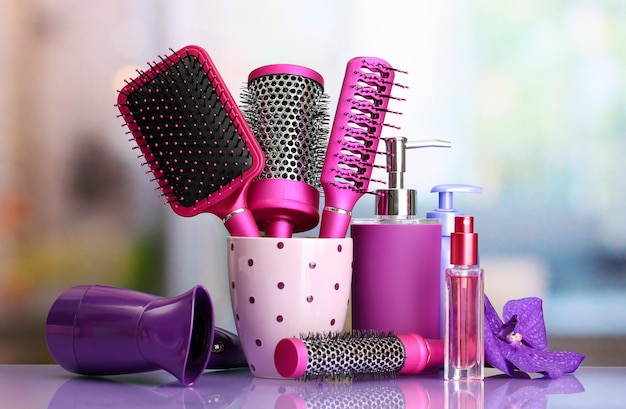 Hair brushes hairdryer and cosmetic bottles in beauty salon