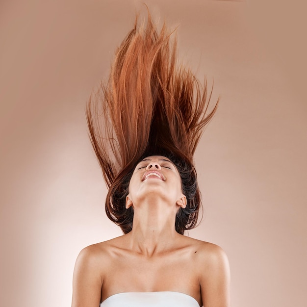 Foto bellezza e cosmetici per la cura dei capelli di una donna sullo sfondo dello studio per il trattamento del salone di lusso con prodotto shampoo primo piano del volto del modello estetico in posa per il mockup di cura della pelle e benessere del parrucchiere