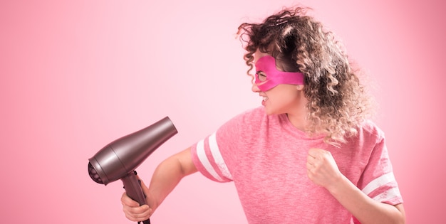 Hair care, cute woman with hair dryer in hand