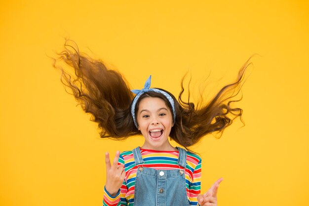 헤어 케어 휴가 시간 내부 에너지 패션 트렌드 작은 패셔니스타 노란색 배경 귀여운 아이 패션 소녀 여름 패션 개념 활동적인 라이프 스타일 소녀 긴 곱슬 머리 묶인 머리 스카프
