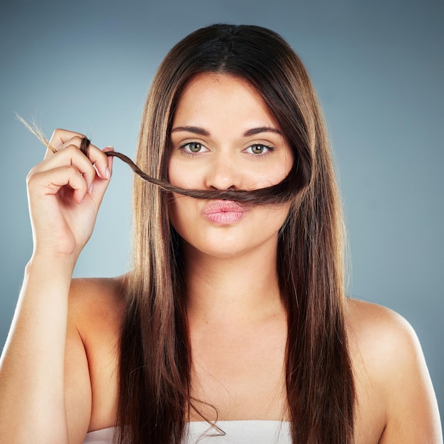 Hair care funny and woman with salon straight hair wellness and beauty against a blue background in studio Comic luxury and portrait of a model with quality hair salon treatment from hairdresser