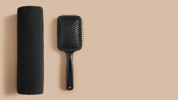 Foto kit per la cura dei capelli asciugamano pettine nero su sfondo beige