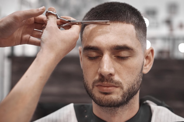 Hair Care. Men's hairstyles in hairdressing salons. Barber makes a haircut and beard to his client.