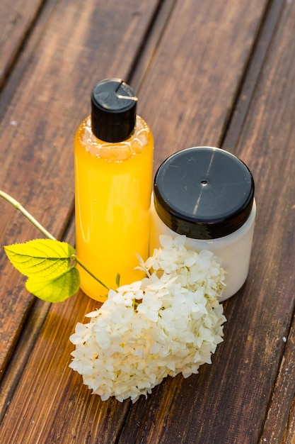 Hair care products shot near hydrangea flower.