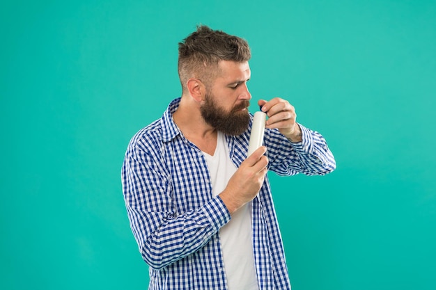 Foto trattamento per la cura dei capelli barbiere e cura dei capelli concetto di revisione dello shampoo testare il prodotto di bellezza lancio del prodotto di bellezza balsamo o lozione per capelli uomo barbuto hipster bottiglia di shampoo o gel doccia