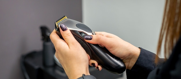 Tagliatore di capelli nelle mani del parrucchiere professionista femminile o del barbiere nel parrucchiere