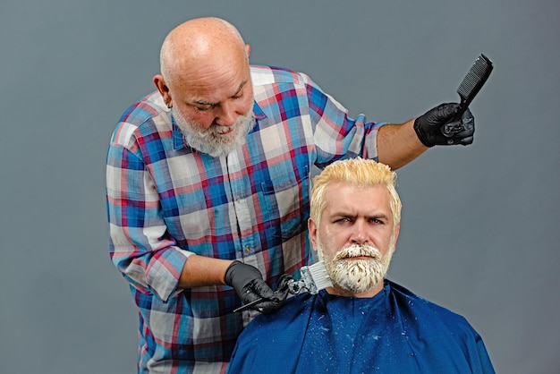 Hair coloring in gray color process hairdresser applying colorful tint on man models hair advertisin