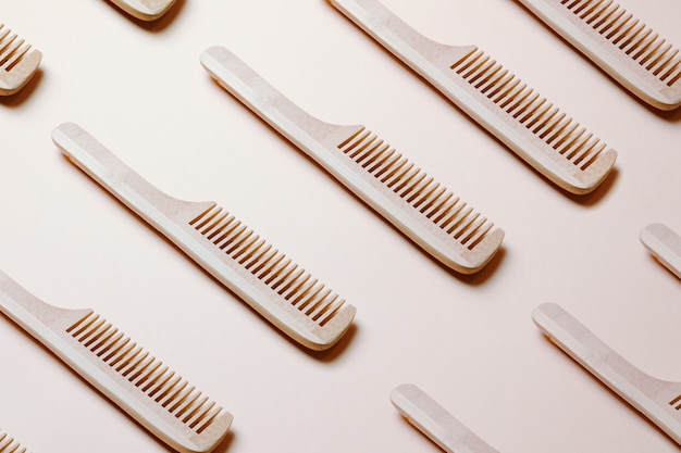 Hair comb pattern on pink pastel background top view,\
repetitive pattern, design background, hair dressing\
minimalist