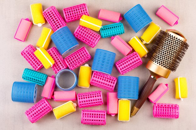 Hair curlers of different colors and the comb top view closeup