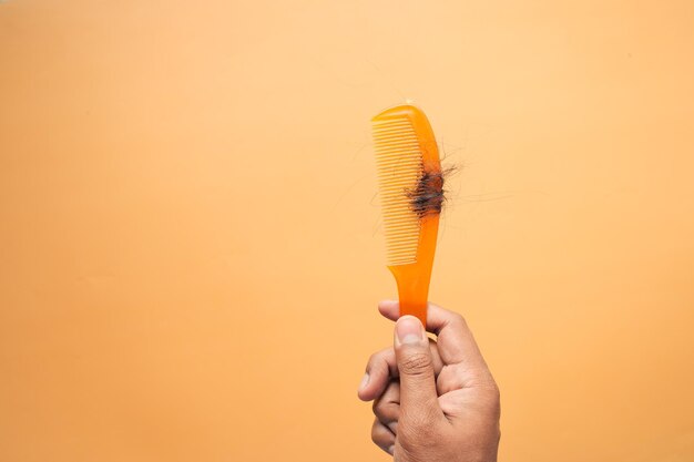 Hair loss in orange color comb hair fall everyday serious\
problem