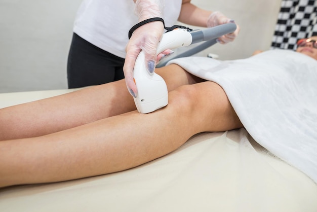 Hair removal on the legs laser procedure at medical clinic\
beautiful smooth female legs in beauty salon spa concept laser skin\
care banner